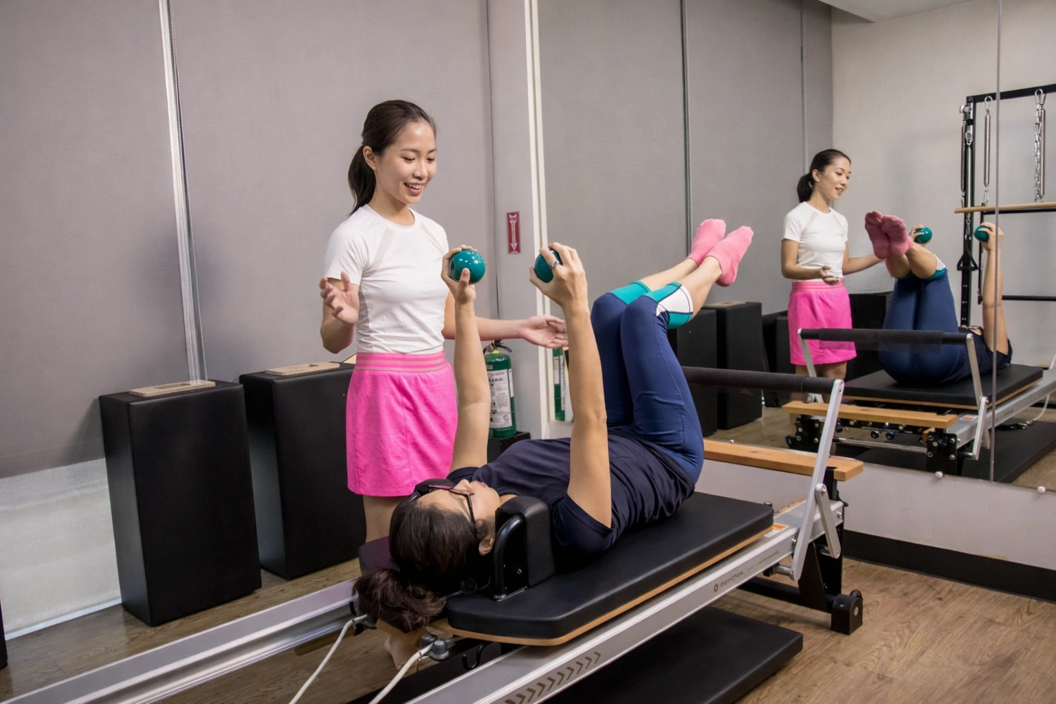 An experienced physical therapist guiding a client through an exercise at Halcyon gym